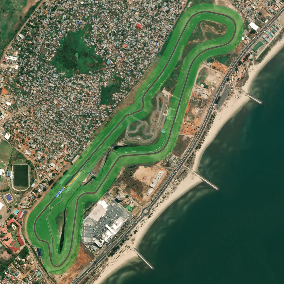 Top-down preview of ATCM - Automóvel & Touring Clube de Moçambique with the generated road, kerbs and grid overlaid on satellite imagery